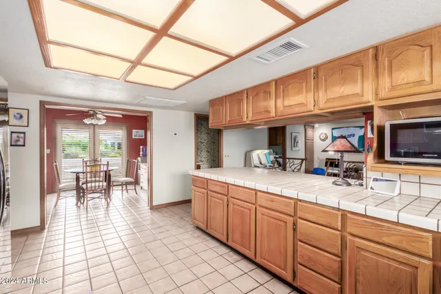 a kitchen with stainless steel appliances granite countertop a sink a stove cabinets dining table and chairs