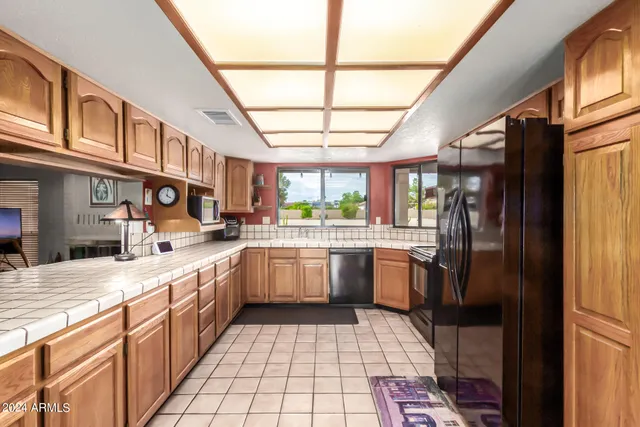 a large kitchen with stainless steel appliances granite countertop a sink and cabinets