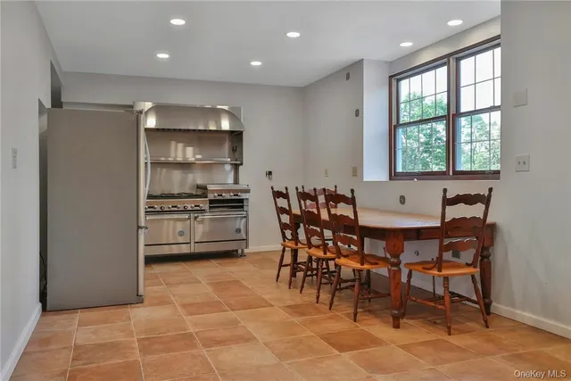 a kitchen with stainless steel appliances a table and chairs in it