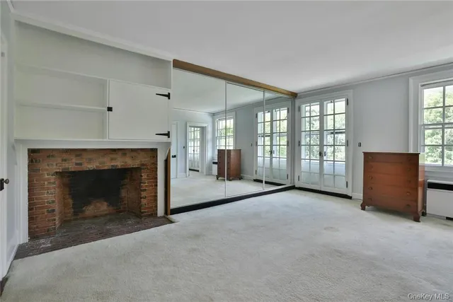 a view of an empty room with a fireplace and a window