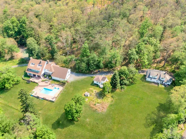 an aerial view of residential house with outdoor space and trees all around