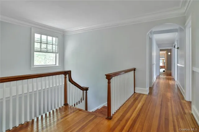 a view of a hallway with wooden floor and staircase