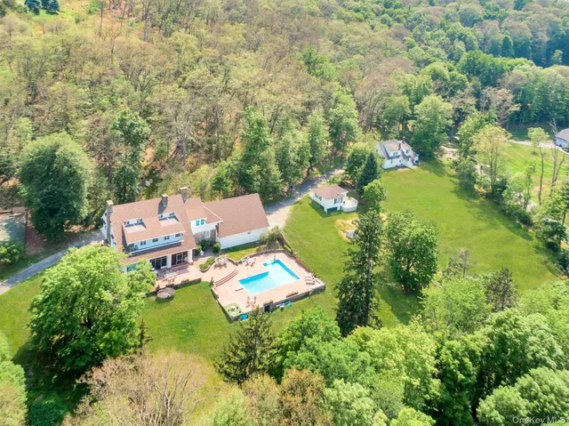 an aerial view of residential house with outdoor space and trees all around