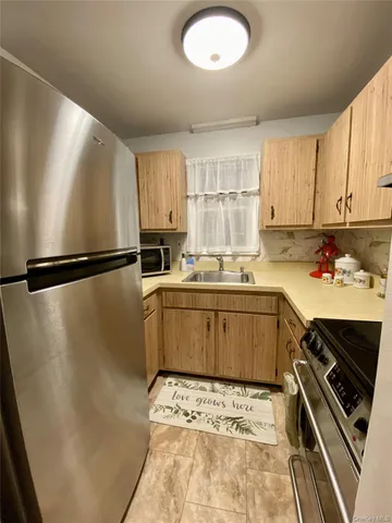 a kitchen with a refrigerator sink and cabinets