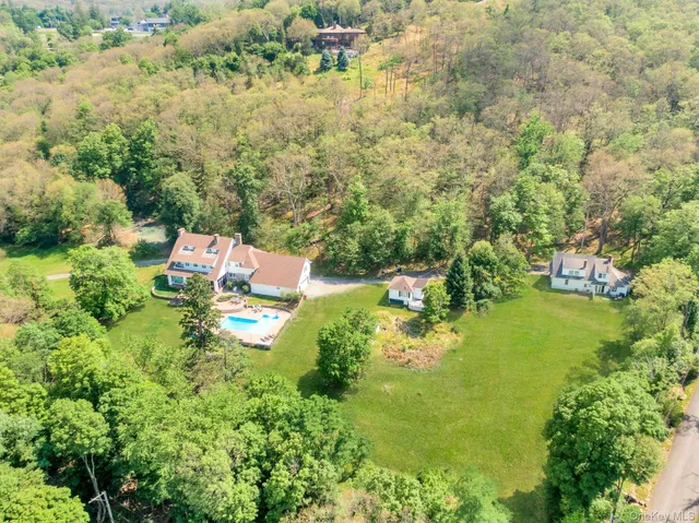 an aerial view of residential house with outdoor space and trees all around
