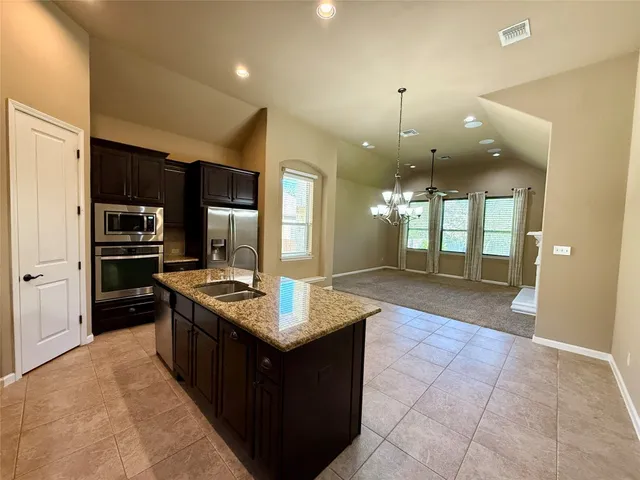 a kitchen with stainless steel appliances granite countertop a stove a sink a refrigerator and a oven
