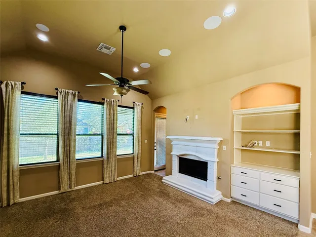 a view of an empty room with a fireplace and a window