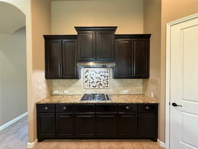 a view of kitchen with granite countertop cabinets