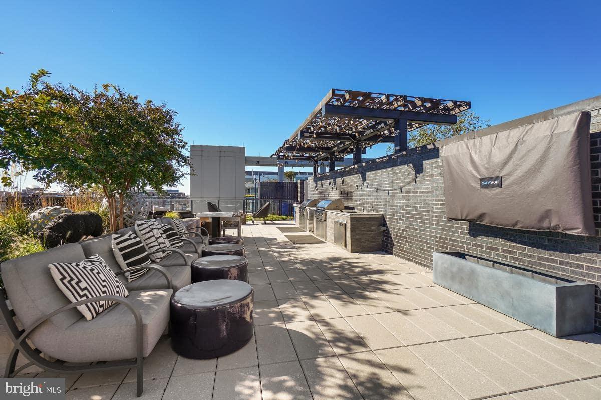 70 N Street Southeast, Unit N1016 Washington, DC 20003 - Photo 14 of 21 a view of a patio with couches chairs and a fire pit