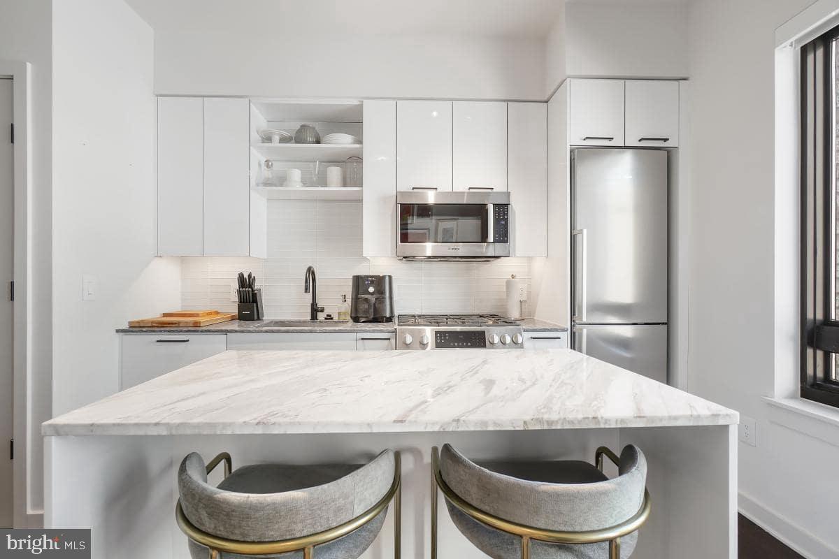70 N Street Southeast, Unit N1016 Washington, DC 20003 - Photo 2 of 21 a kitchen with stainless steel appliances granite countertop a sink a stove and a refrigerator