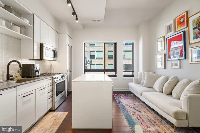 a living room with furniture and a kitchen