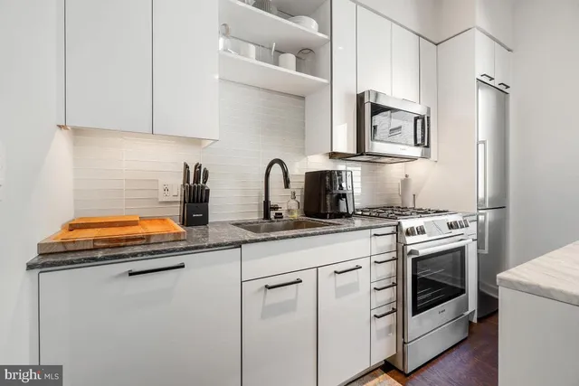 a kitchen with white cabinets and white appliances