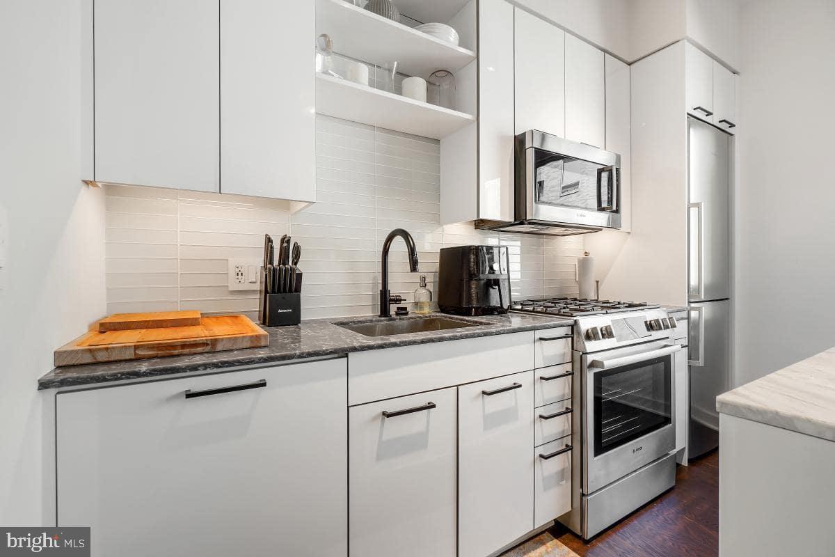 70 N Street Southeast, Unit N1016 Washington, DC 20003 - Photo 4 of 21 a kitchen with white cabinets and white appliances