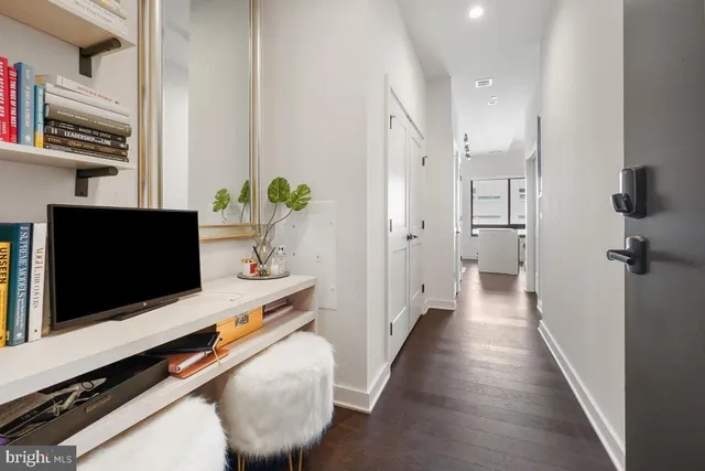 a hallway with view of living room and flat screen tv
