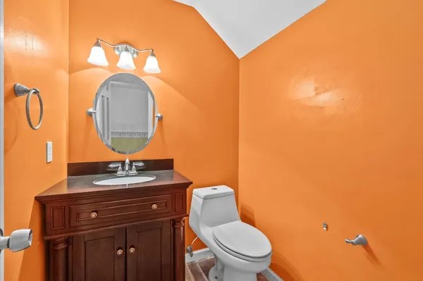 a bathroom with a toilet sink vanity granite and mirror