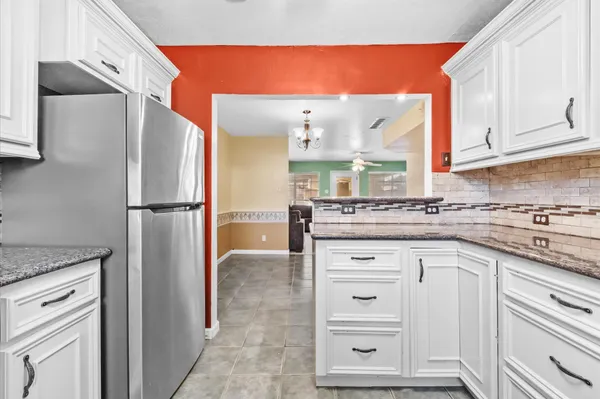 a kitchen with stainless steel appliances granite countertop a refrigerator and a stove