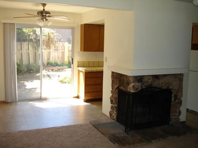 a living room with a fireplace and a large window