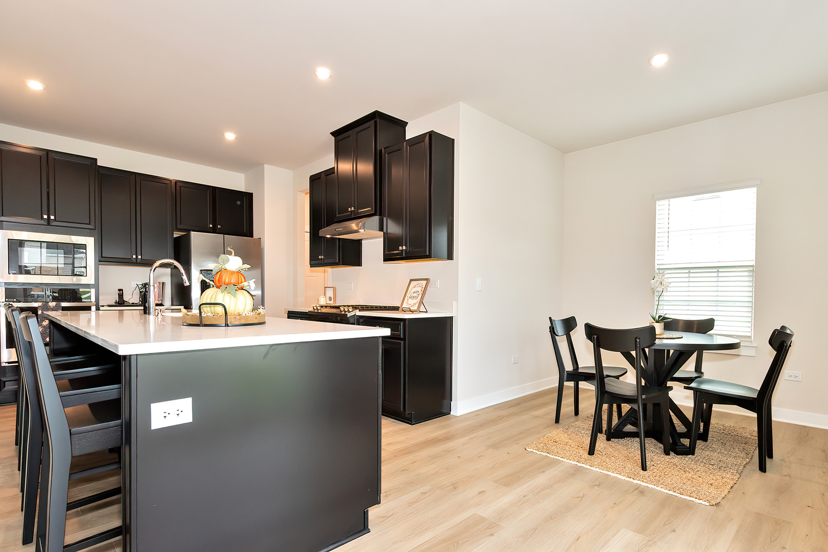 1241 Neuway Lane Antioch, IL 60002 - Photo 5 of 20 a kitchen with kitchen island granite countertop a dining table chairs and a refrigerator