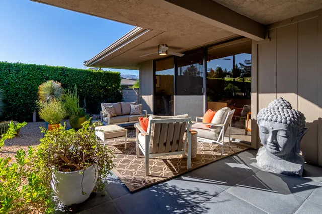 a view of a patio with table and chairs potted plants
