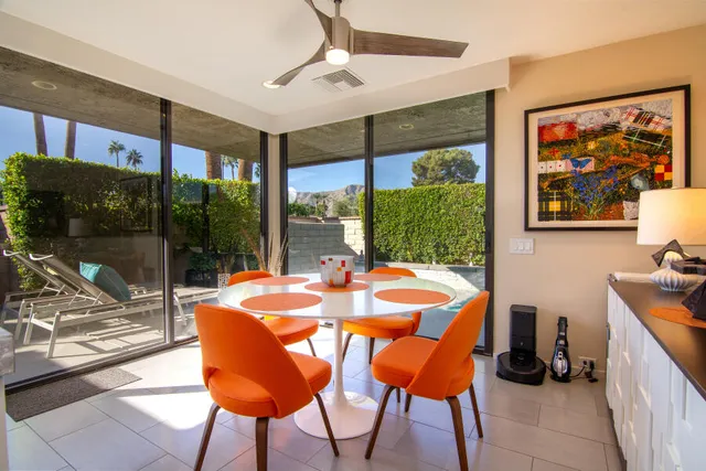a dining room with furniture and a floor to ceiling window