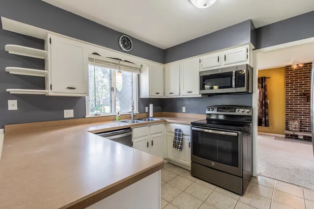 a kitchen with stainless steel appliances a stove microwave and sink