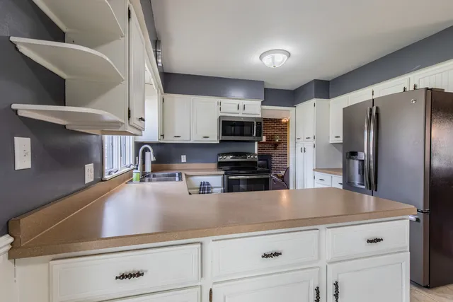 a kitchen with kitchen island a counter top space cabinets stainless steel appliances and cabinets