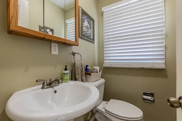 a bathroom with a sink a mirror and a toilet