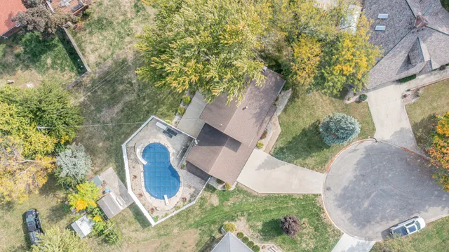 an aerial view of a house with yard and swimming pool