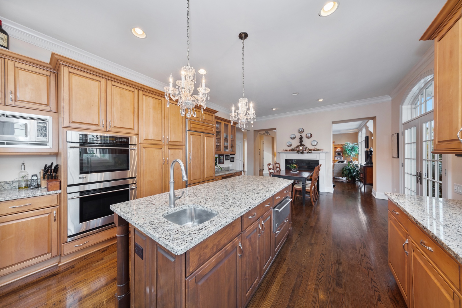 46 Willowcrest Drive Oak Brook, IL 60523 - Photo 7 of 25 a kitchen with stainless steel appliances granite countertop a refrigerator a stove top oven a sink dishwasher and a dining table with wooden floor