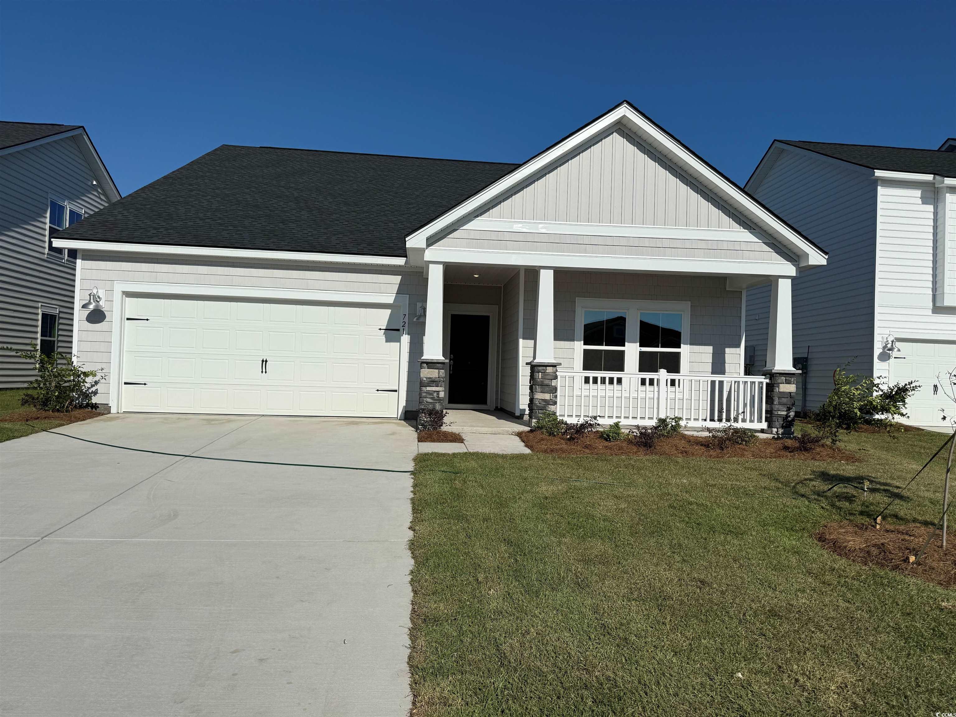 721 Laconic Drive Myrtle Beach, SC 29588 - Photo 1 of 17 Craftsman-style house with an attached garage, a front lawn, board and batten siding, concrete driveway, and covered porch