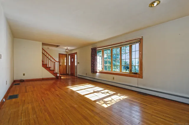 wooden floor in an empty room with a window
