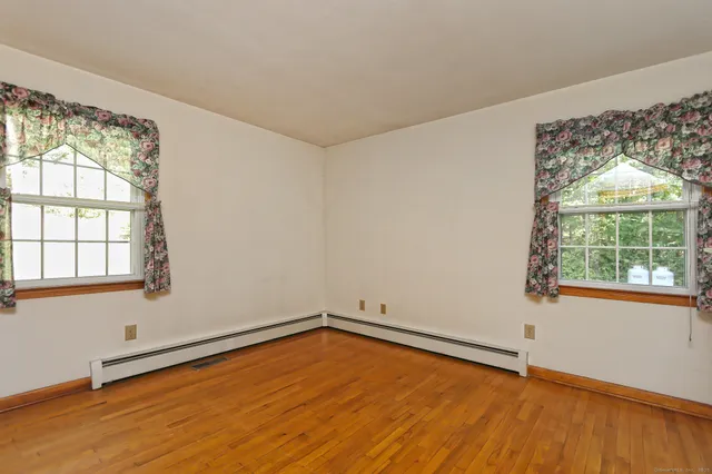 wooden floor in an empty room with a window