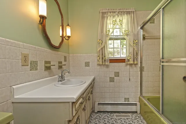 a bathroom with a sink a mirror and shower