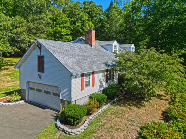 a view of a house with a yard and large tree