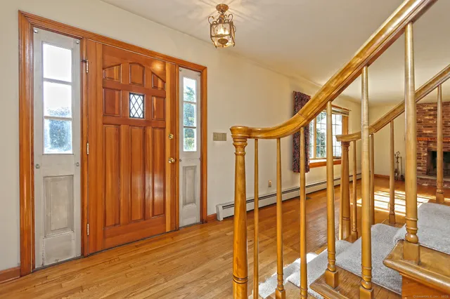 a view of an entryway with wooden floor and door