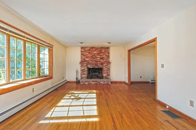 a view of an empty room with a fireplace and a window
