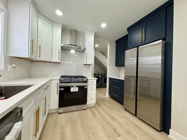 a kitchen with stainless steel appliances a sink a stove top oven a counter space and cabinets