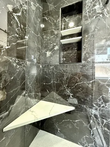 a view of staircase with lots of frames on wall and a window