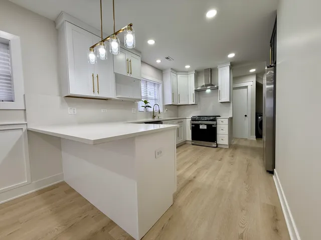 a kitchen with stainless steel appliances granite countertop a refrigerator and a stove
