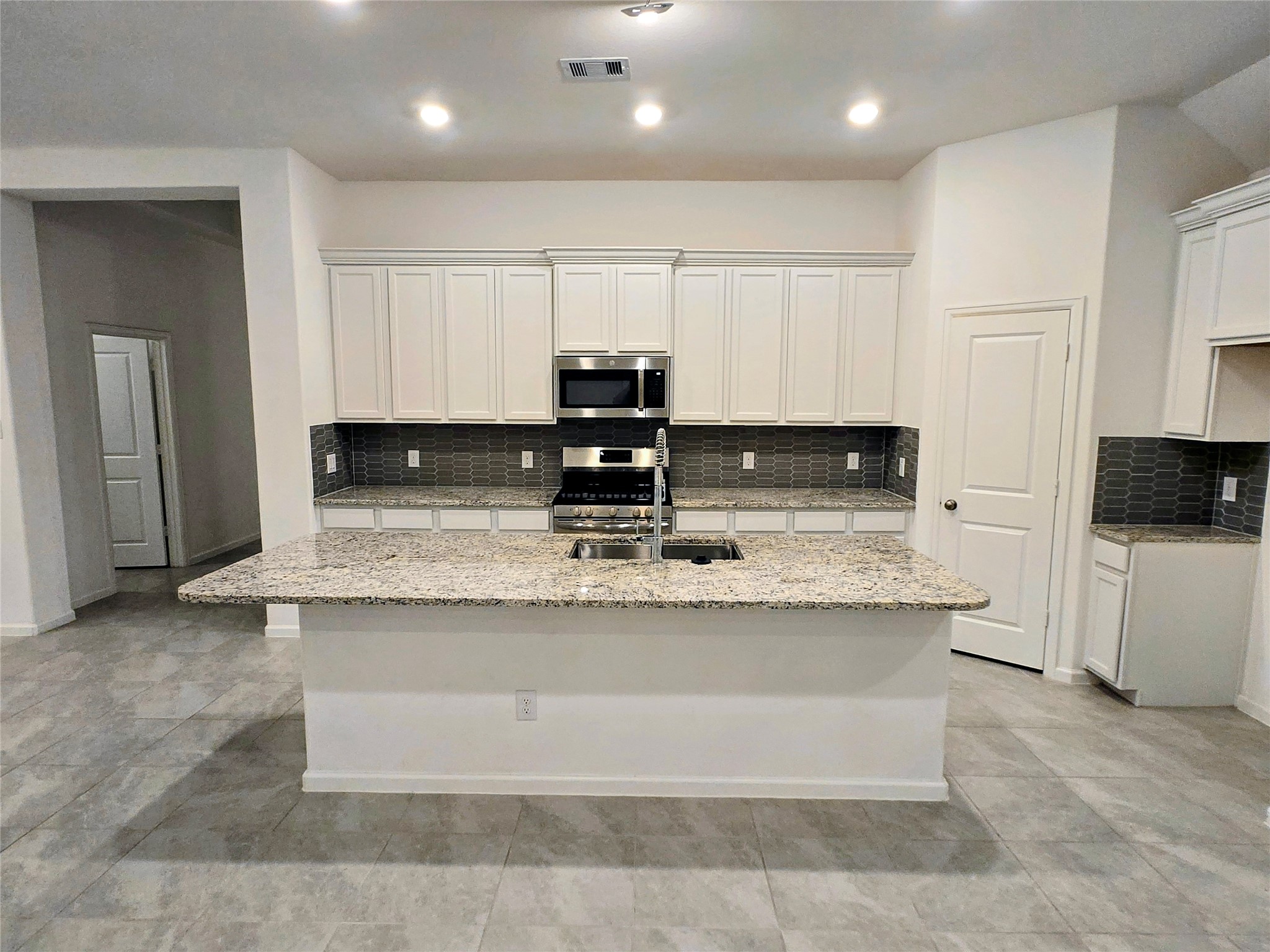 3632 Richmont Court Rosenberg, TX 77469 - Photo 7 of 23 a kitchen with stainless steel appliances granite countertop a sink a stove and a refrigerator
