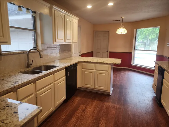 a kitchen with a sink window and cabinets