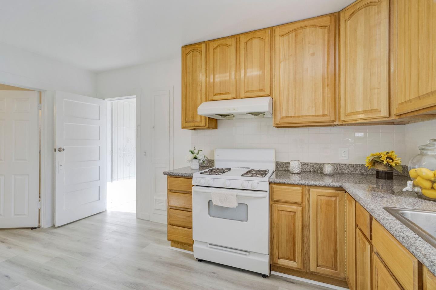 3618 MacArthur Boulevard Oakland, CA 94619 - Photo 16 of 65 a kitchen with stainless steel appliances granite countertop a sink a stove and cabinets with wooden floor
