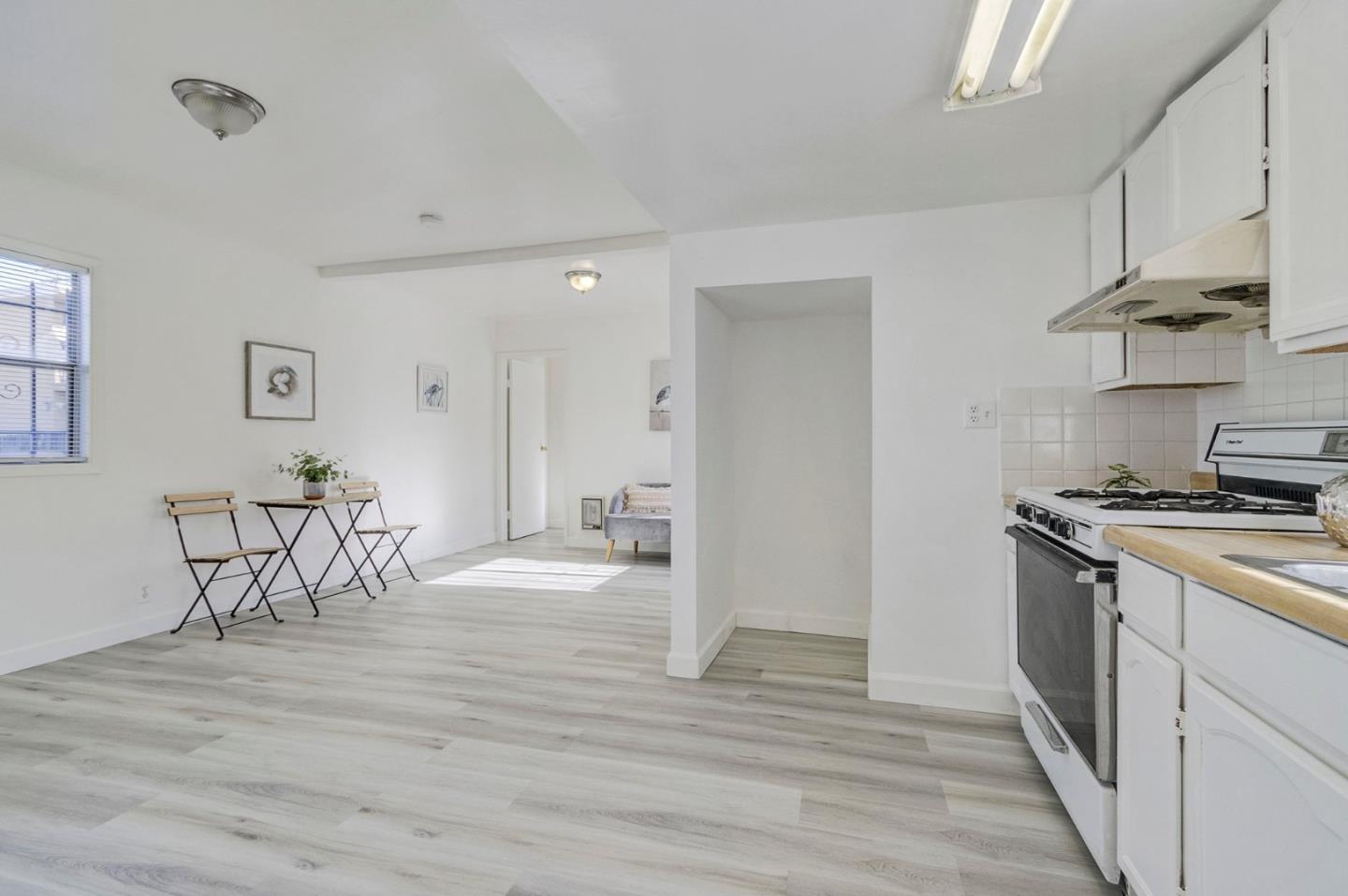 3618 MacArthur Boulevard Oakland, CA 94619 - Photo 34 of 65 a kitchen with stainless steel appliances granite countertop a table chairs stove and white cabinets