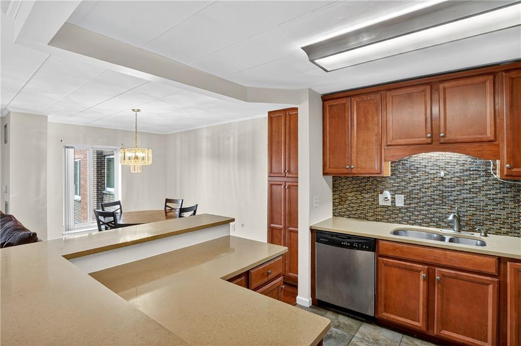 5 Bayard Road, Unit 912 Pittsburgh, PA 15213 - Photo 6 of 36 The open-concept dining area effortlessly flows into the spacious living room, creating a perfect layout for entertaining and everyday living. A large entertainment center anchors the room, complemented by a comfortable couch—offering both style and functionality in this inviting, well-designed space.