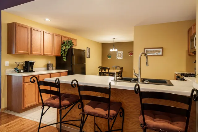 a kitchen with a table chairs refrigerator and cabinets