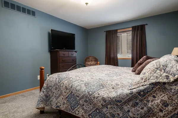 a bedroom with a bed and a flat screen tv