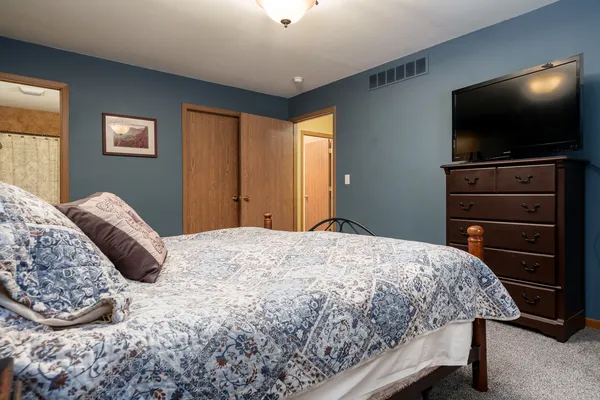 a bedroom with a bed and a flat screen tv
