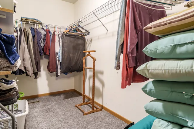 a view of walk in closet with clothes and shoes
