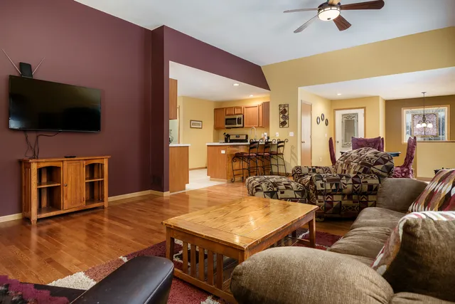 a living room with furniture flat screen tv and kitchen view