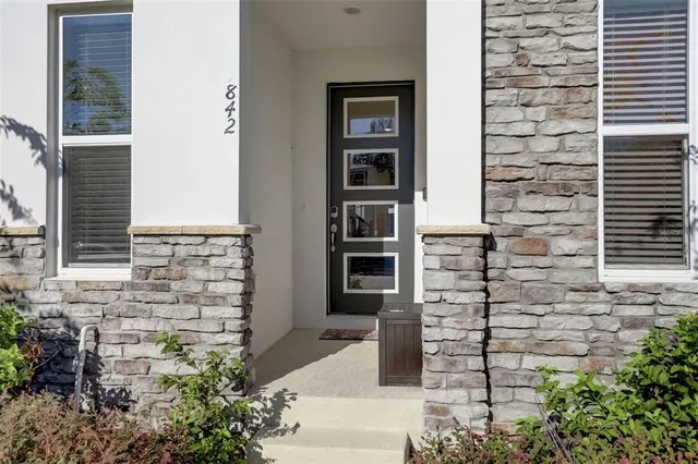 a brick building with a window and potted plants